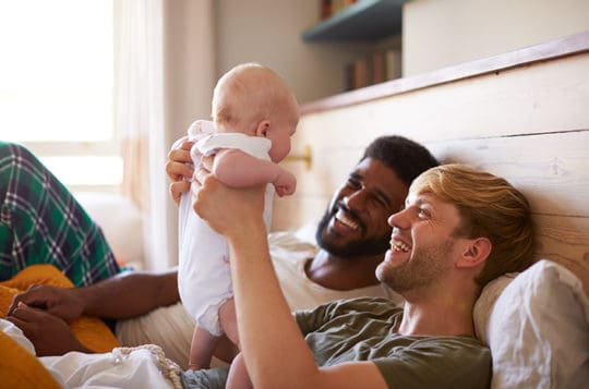 couple laying down with new born