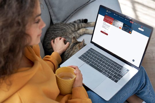 Woman using online banking setting up account alerts with cat