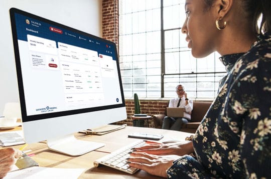 Woman using online banking looking at account dashboard in office