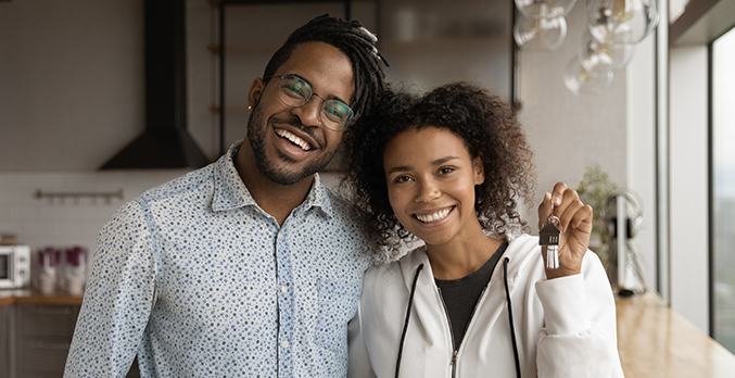 couple holding keys to home