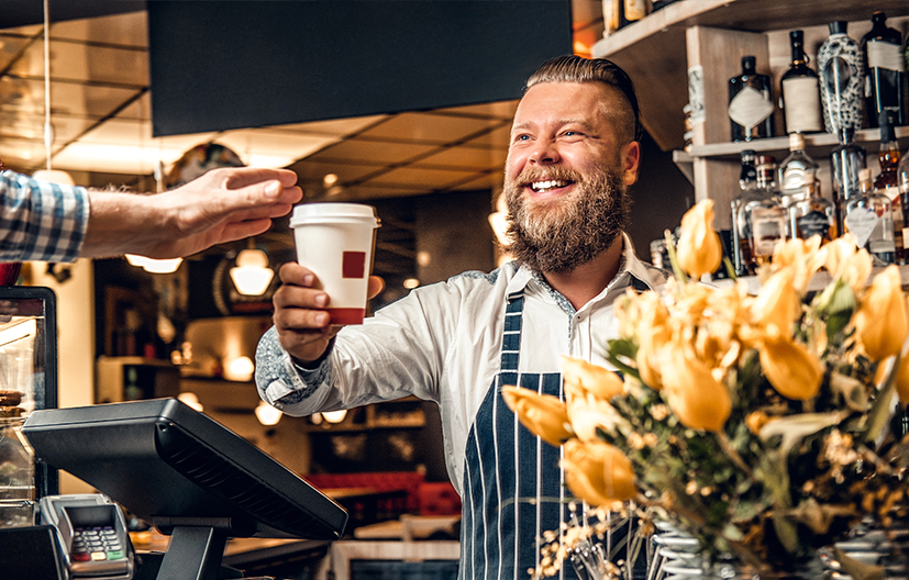 coffee shop owner holding drink