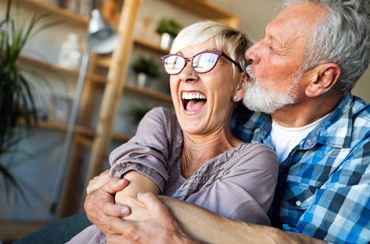 couple laughing and cuddling on the sofa