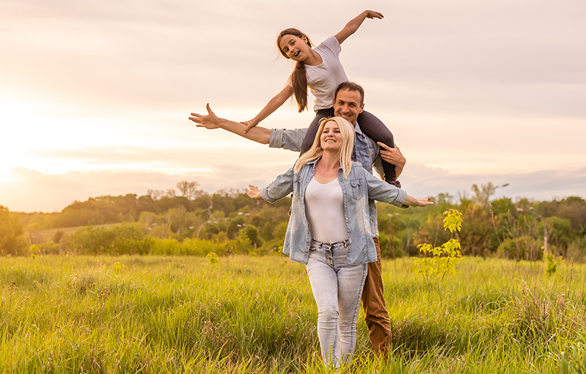 family playing in a field at sunset