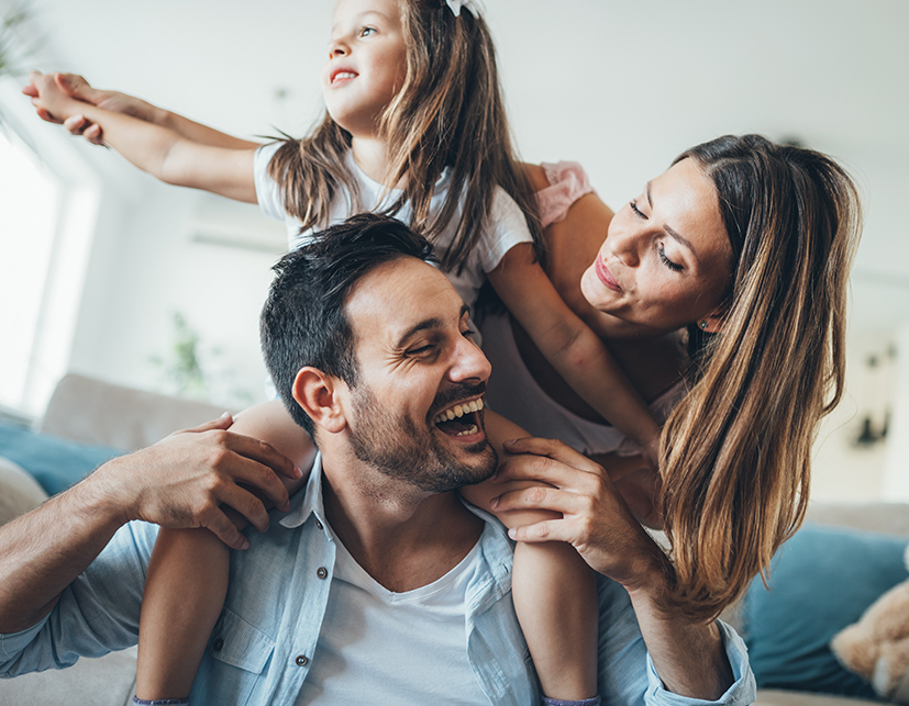 Husband and wife playing with daughter on shoulders