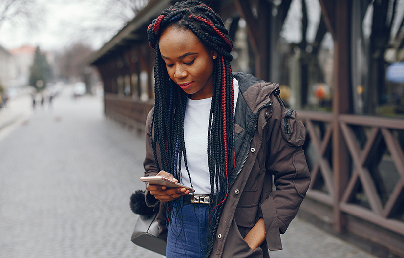 woman in front of bridge on phone